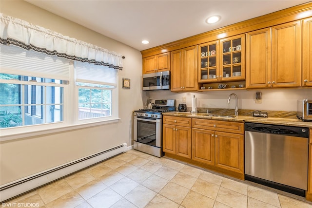 kitchen with appliances with stainless steel finishes, a sink, baseboard heating, brown cabinets, and recessed lighting