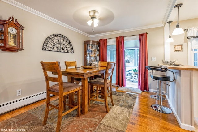 dining area with a baseboard radiator, ornamental molding, wood finished floors, a ceiling fan, and baseboards