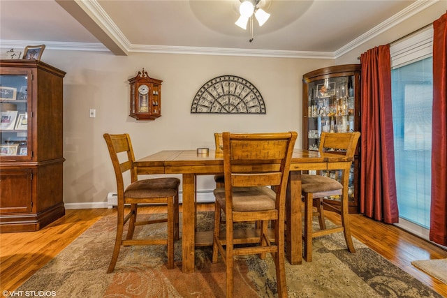 dining space featuring wood finished floors, a ceiling fan, healthy amount of natural light, ornamental molding, and baseboards