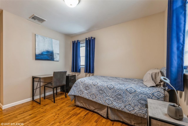 bedroom featuring wood finished floors and baseboards