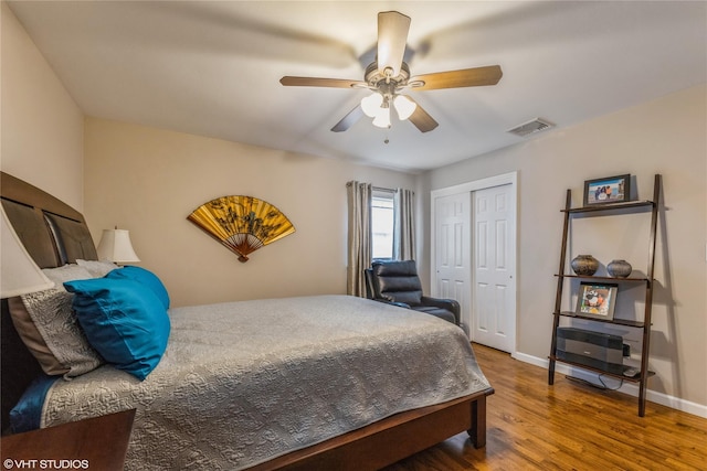 bedroom with wood finished floors, a closet, a ceiling fan, and baseboards