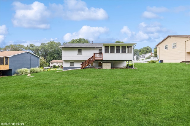 rear view of property with a sunroom, stairway, and a lawn
