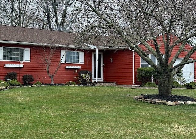 view of front of house featuring a front yard and a shingled roof
