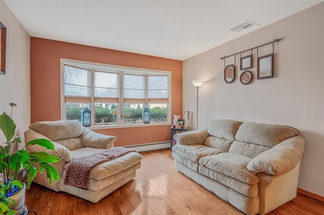 living area featuring a baseboard radiator, wood finished floors, and baseboards