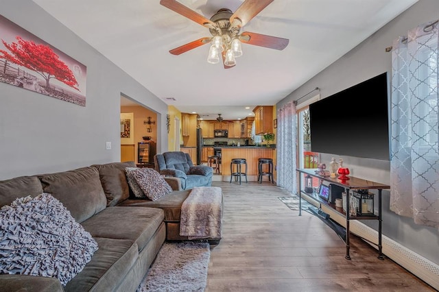 living room featuring ceiling fan and light wood-type flooring