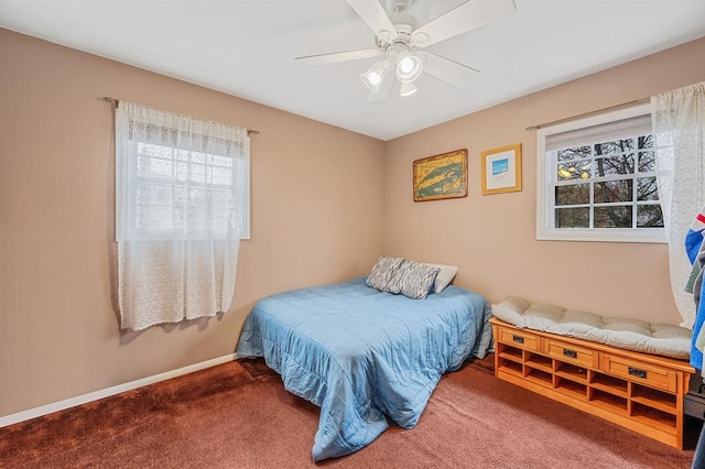 carpeted bedroom featuring multiple windows, baseboards, and a ceiling fan