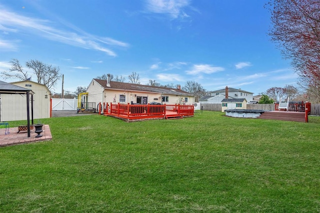 rear view of property with a deck, a gazebo, and a gate