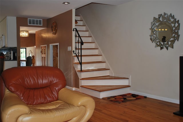 stairs with wood finished floors, baseboards, and recessed lighting