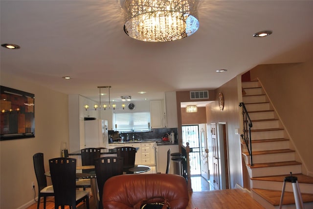 dining room featuring stairs, a chandelier, recessed lighting, and baseboards