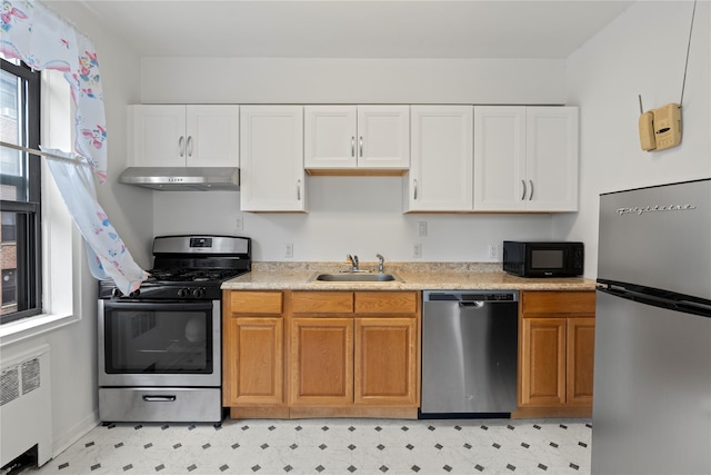16 N Broadway Unit 4R, White Plains, NY 10601 - kitchen featuring appliances with stainless steel finishes, radiator, a sink, under cabinet range hood, and light countertops