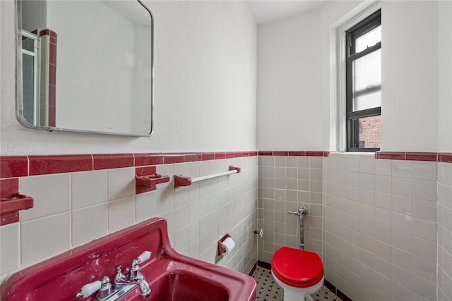 16 N Broadway Unit 4R, White Plains, NY 10601 - bathroom featuring tile walls, wainscoting, toilet, and a sink