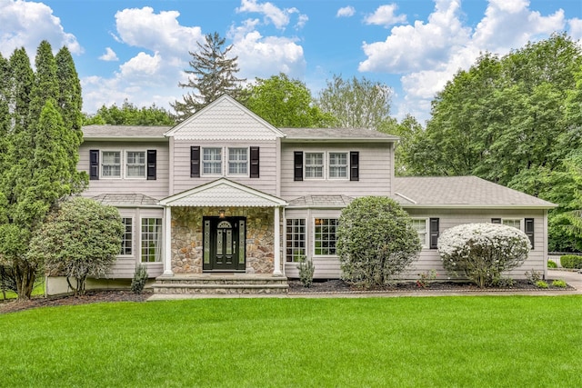 view of front facade featuring a front yard and stone siding
