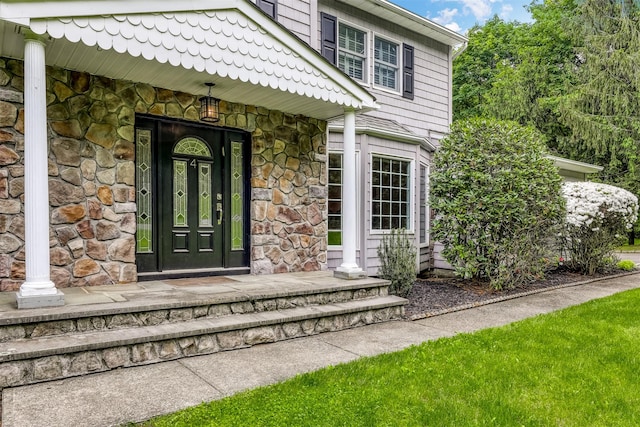 property entrance featuring stone siding and covered porch
