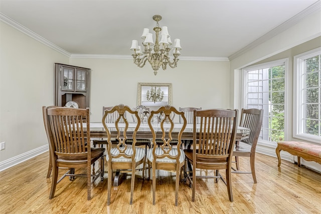 dining room with a chandelier, ornamental molding, light wood-style flooring, and baseboards