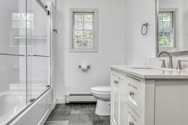 full bath with baseboard heating, toilet, vanity, baseboards, and shower / bath combination with glass door