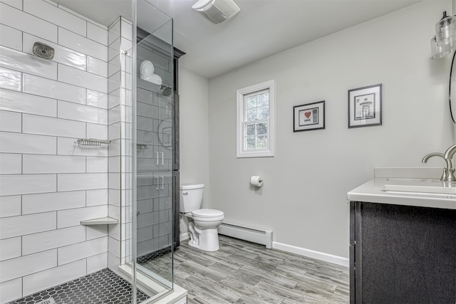 bathroom featuring a baseboard heating unit, toilet, a stall shower, vanity, and baseboards