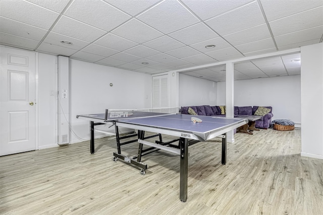 rec room featuring light wood finished floors, a paneled ceiling, and baseboards