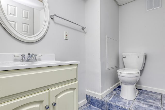 half bath featuring toilet, vanity, baseboards, and tile patterned flooring