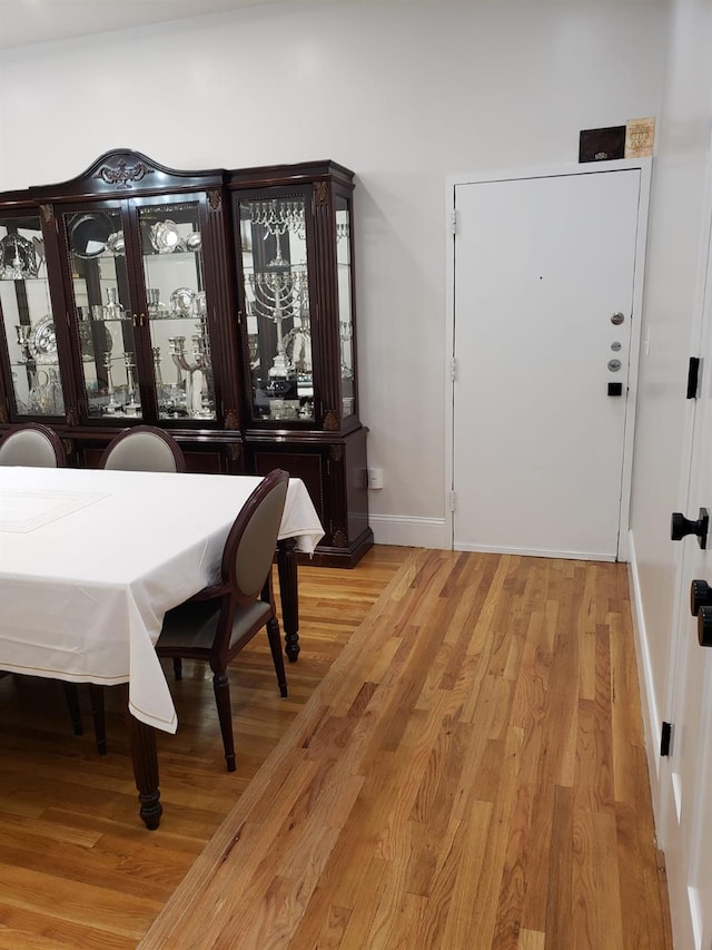 dining space featuring light wood finished floors and baseboards