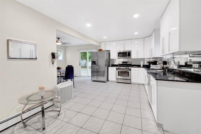 680 Corbalis Pl, Yonkers, NY 10703 - kitchen with stainless steel appliances, dark countertops, white cabinets, a baseboard radiator, and recessed lighting