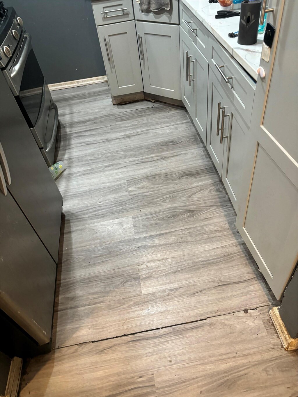 117-30 220th St, Cambria Heights, NY 11411 - kitchen with light wood-style flooring, gray cabinetry, and baseboards