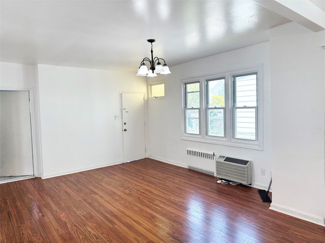 unfurnished dining area featuring radiator heating unit, wood finished floors, a chandelier, baseboards, and heating unit
