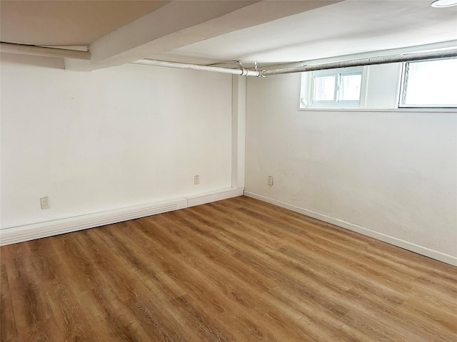 basement featuring baseboards and wood finished floors