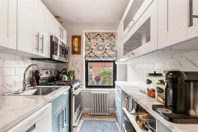 316 Richbell Rd Unit C2, Mamaroneck, NY 10543 - kitchen with radiator heating unit, stainless steel appliances, white cabinetry, and blue cabinetry