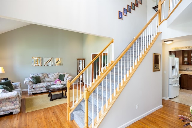 21 Coventry Ln, Smithtown, NY 11787 - stairway featuring a towering ceiling, wood finished floors, and baseboards