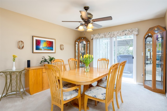 dining room with light carpet, baseboards, and ceiling fan