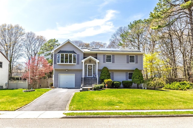 split foyer home with a garage, asphalt driveway, and central AC unit