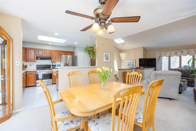 dining space with a skylight, light carpet, ceiling fan, and recessed lighting