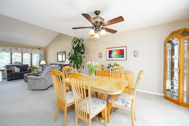 dining space featuring light colored carpet, ceiling fan, lofted ceiling, and baseboards