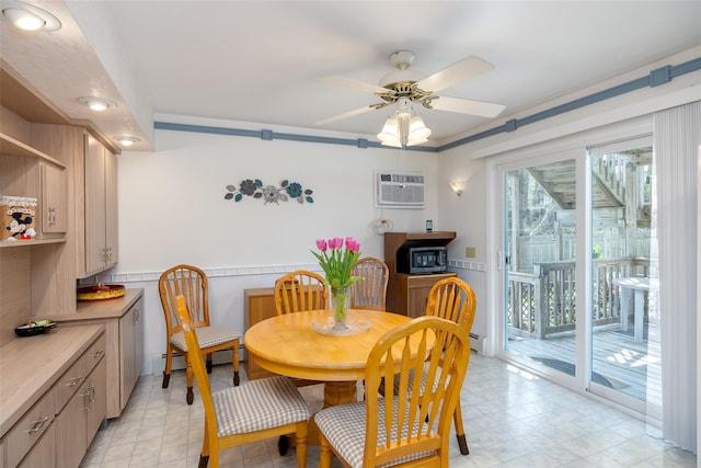 dining space featuring a wall unit AC, wainscoting, a ceiling fan, a baseboard heating unit, and light floors