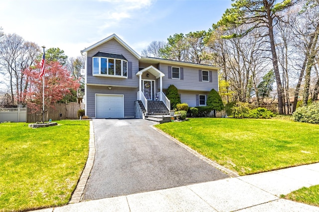 raised ranch featuring asphalt driveway and an attached garage