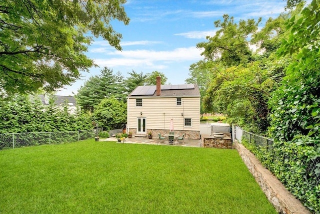 2356 Palmer Ave, New Rochelle, NY 10801 - back of house with a patio, roof mounted solar panels, french doors, a fenced backyard, and a chimney