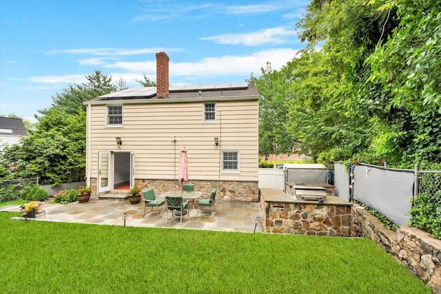 2356 Palmer Ave, New Rochelle, NY 10801 - back of house featuring a patio area, roof mounted solar panels, a chimney, and a fenced backyard