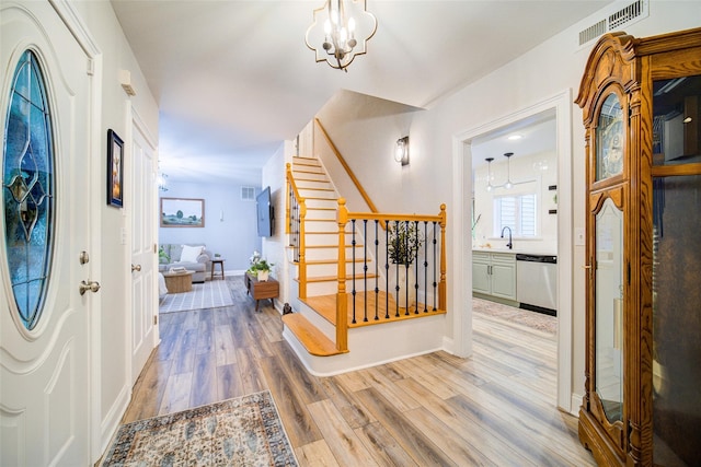 444 Haviland Hollow Rd, Patterson, NY 12563 - foyer entrance featuring light wood finished floors, stairs, a chandelier, and baseboards