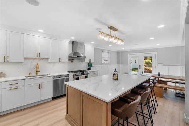 50 Old Dutch Hollow Rd, Monroe, NY 10950 - kitchen with wall chimney range hood, stainless steel appliances, a kitchen island, a wainscoted wall, and a breakfast bar