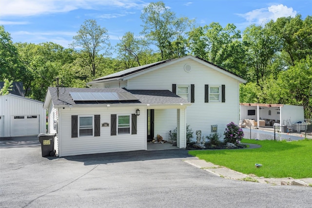 50 Old Dutch Hollow Rd, Monroe, NY 10950 - view of front facade featuring roof mounted solar panels, an outdoor structure, a shingled roof, a front lawn, and driveway