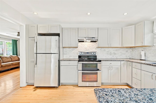 21 James Rd, Monroe, NY 10950 - kitchen with stainless steel appliances, under cabinet range hood, light wood-style flooring, light stone countertops, and decorative backsplash