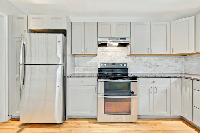 21 James Rd, Monroe, NY 10950 - kitchen with appliances with stainless steel finishes, under cabinet range hood, light stone counters, and light wood-style flooring