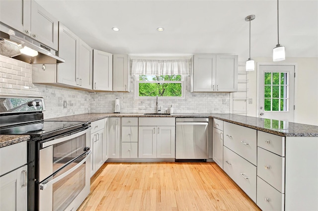 21 James Rd, Monroe, NY 10950 - kitchen with appliances with stainless steel finishes, a sink, under cabinet range hood, a peninsula, and light wood-type flooring