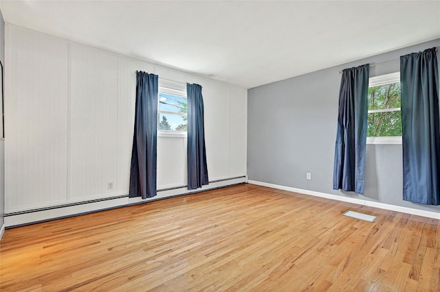 21 James Rd, Monroe, NY 10950 - spare room featuring baseboard heating, healthy amount of natural light, wood finished floors, and baseboards