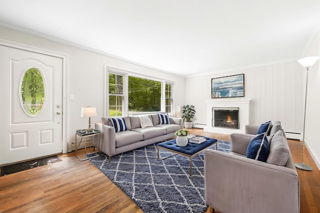 23 Entrance Way, Purdys, NY 10578 - living area featuring wood finished floors, ornamental molding, baseboard heating, and a lit fireplace