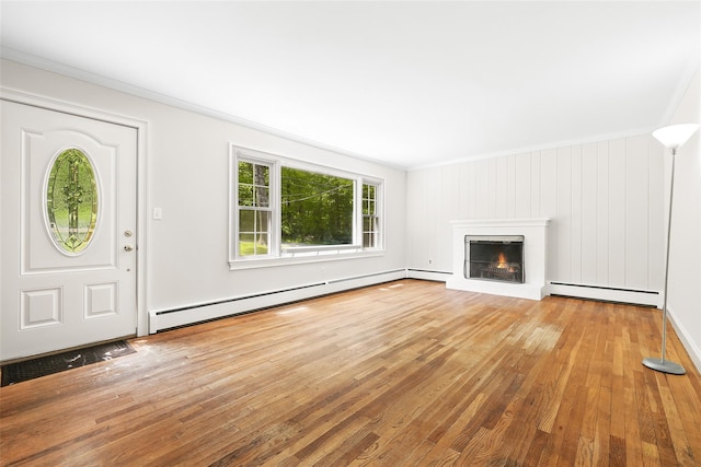 23 Entrance Way, Purdys, NY 10578 - unfurnished living room with a baseboard heating unit, wood-type flooring, crown molding, and a warm lit fireplace