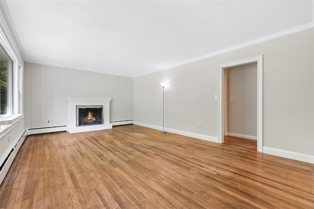23 Entrance Way, Purdys, NY 10578 - unfurnished living room featuring a baseboard heating unit, ornamental molding, light wood-style floors, a warm lit fireplace, and baseboards