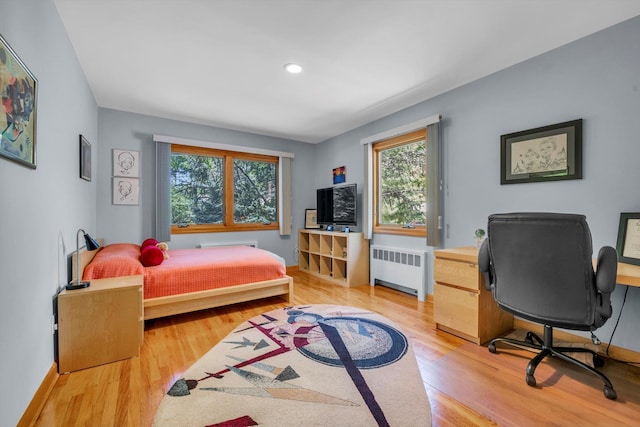 bedroom featuring radiator, light wood-type flooring, baseboards, recessed lighting, and an office area