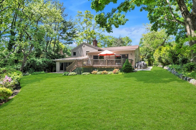 rear view of property with a chimney, a wooden deck, a yard, and stairway