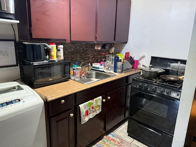 kitchen with black appliances, washer / clothes dryer, a sink, tasteful backsplash, and light countertops